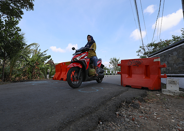 HARUS HATI-HATI: Pengendara melewati akses jalan di Buk Duwur yang sebelumnya diblokir karena jembatan ambles.