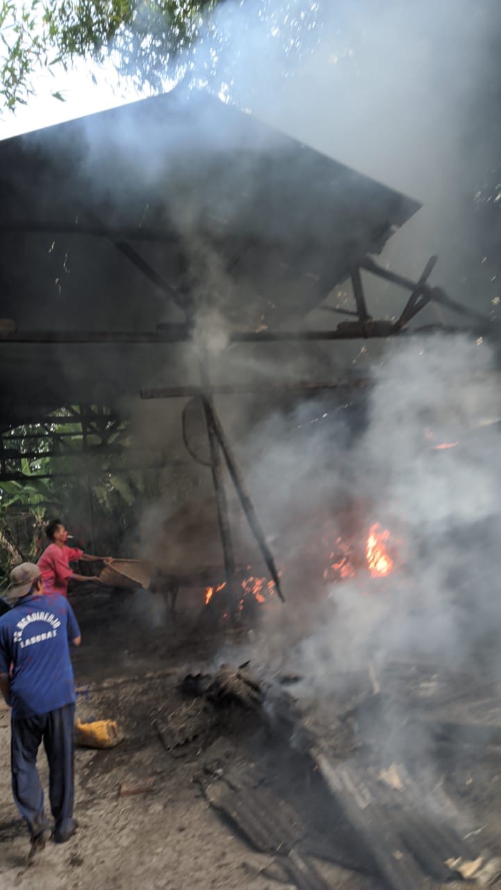 UPAYA LAWAN API: Pekerja pabrik kerupuk berusaha memadamkan api di area produksi yang terbakar di Belung, Desa Kawedusan, Kecamatan Plosoklaten, Minggu sore (2/7).