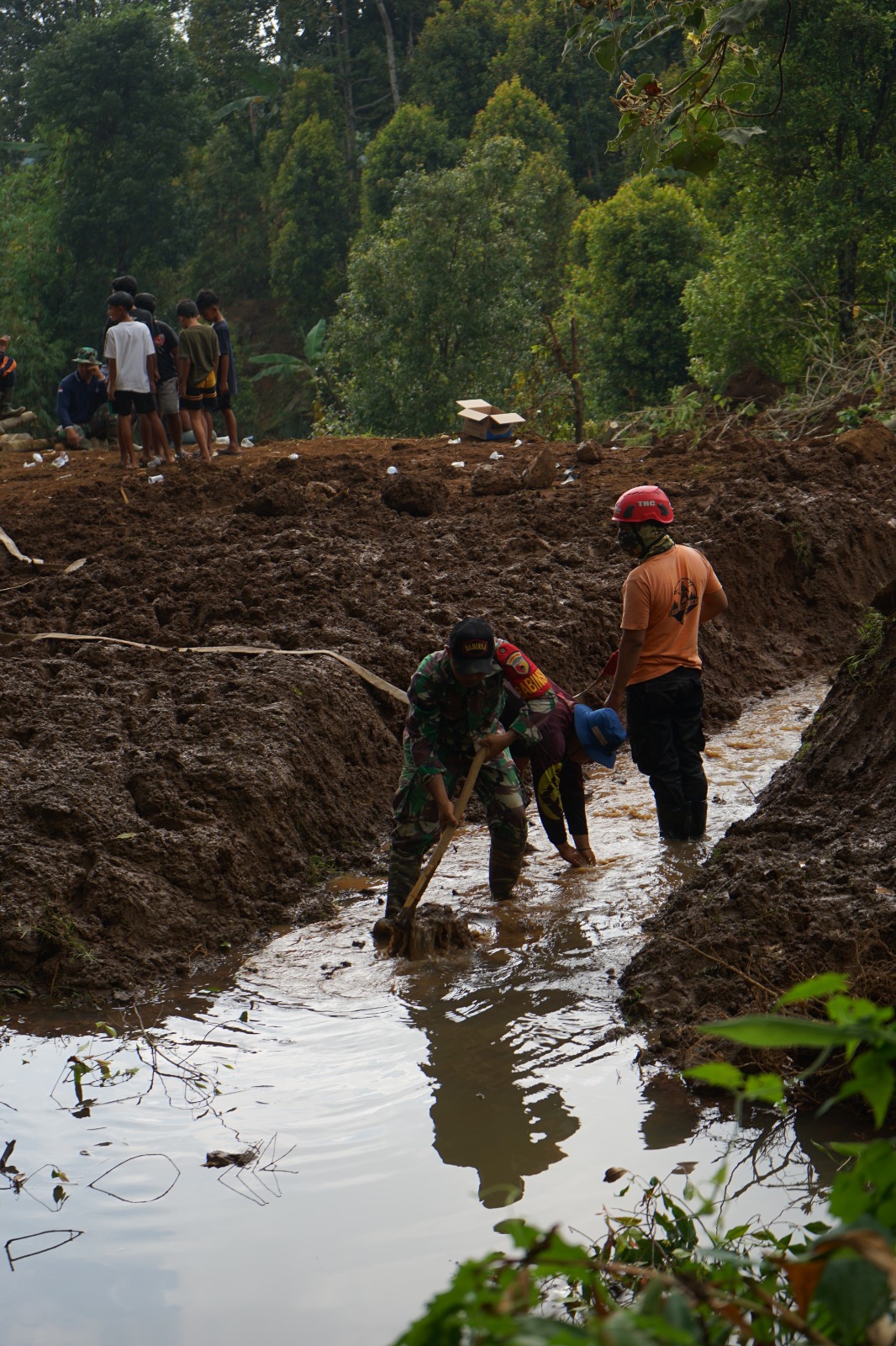 KERJA BAKTI: Warga bersama petugas BPBD membersihan longsor di Dusun Bruno, Desa Ngliman, Kecamatan Sawahan, kemarin pagi.