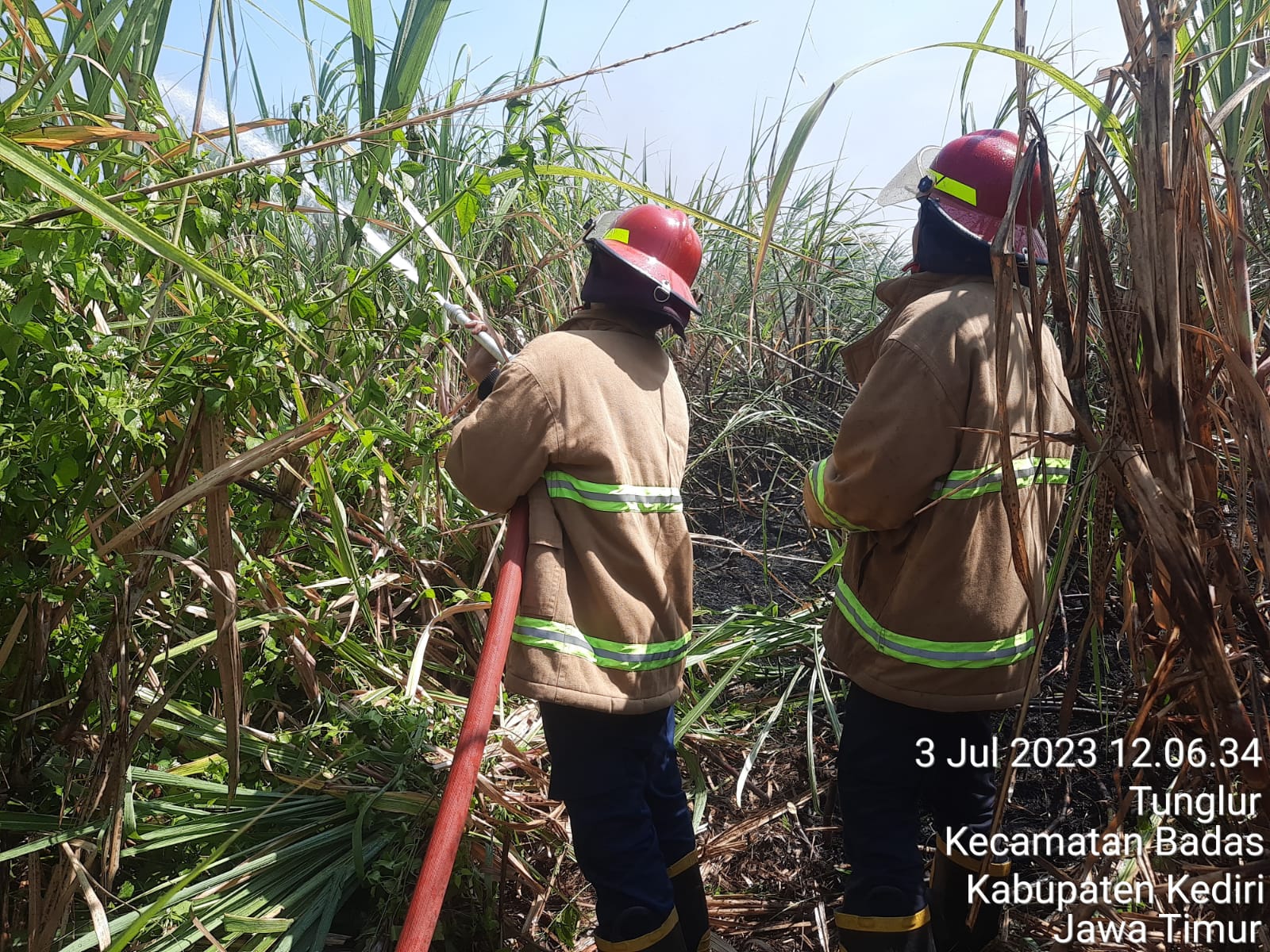 HARUS LEBIH WASPADA: Personel Pasukan Memadamkan Kebakaran (PMK) Kabupaten Kediri menyemprotkan air ke lahan tanaman tebu yang terbakar di wilayah Kecamatan Badas.