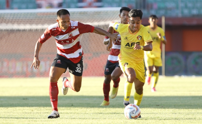 KENA COMEBACK: Pemain Persik Fitra Ridwan berusaha melewati Muhammad Tahir dari Madura United, Minggu (9/7).