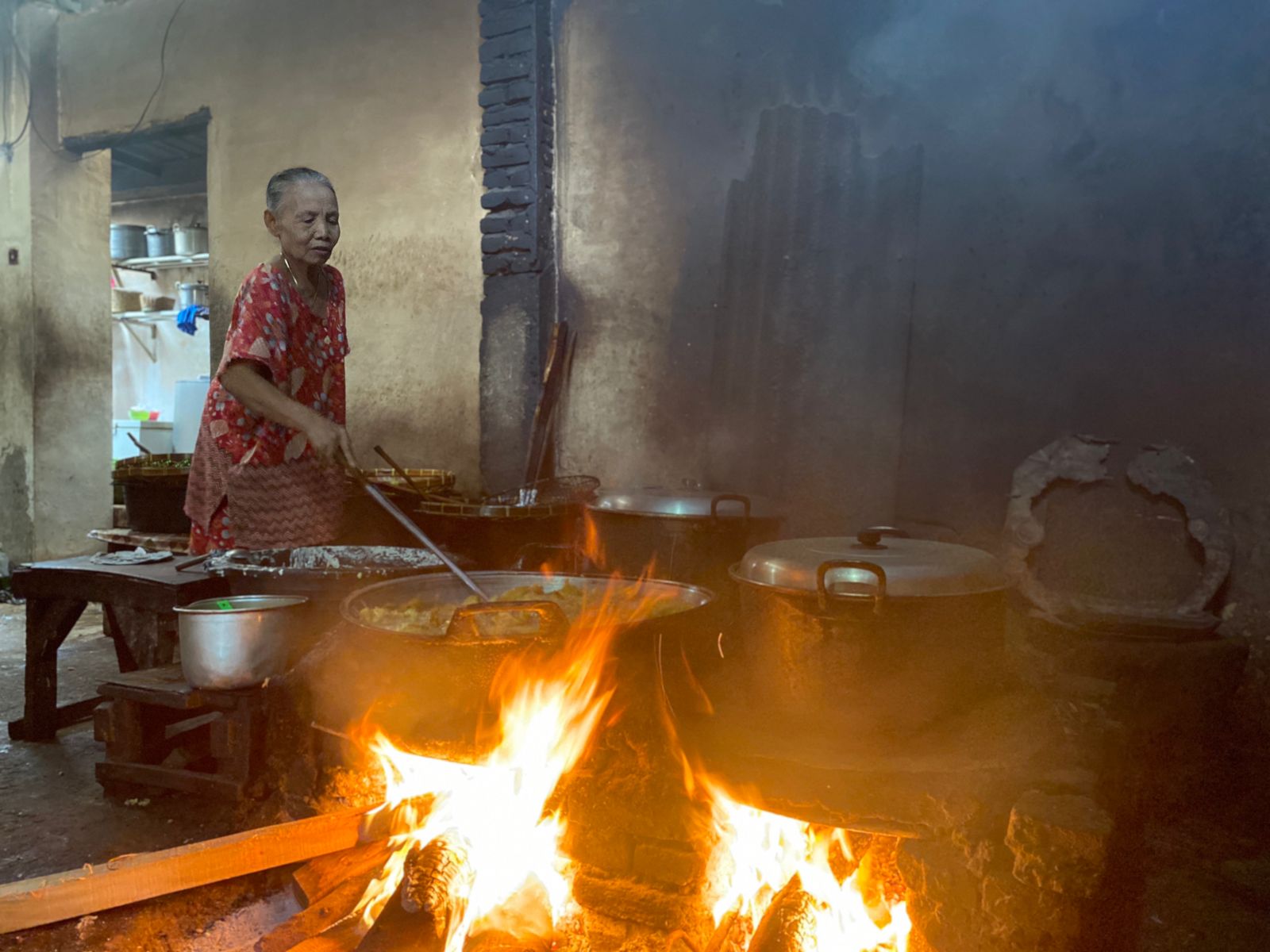 TRADISIONAL: Penik, pemilik warung kerupuk pecel menggoreng tahu di pawon. Dia ogah pakai elpiji agar kualitas rasa terjaga.