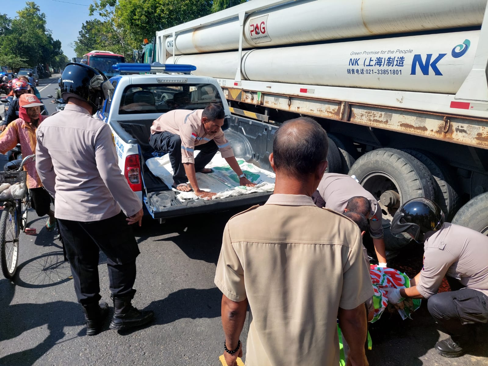 EVAKUASI  Petugas mengangkat tubuh Siti yang terlindas truk HIno. Korban kecelakaan meninggal di lokasi kejadian.
