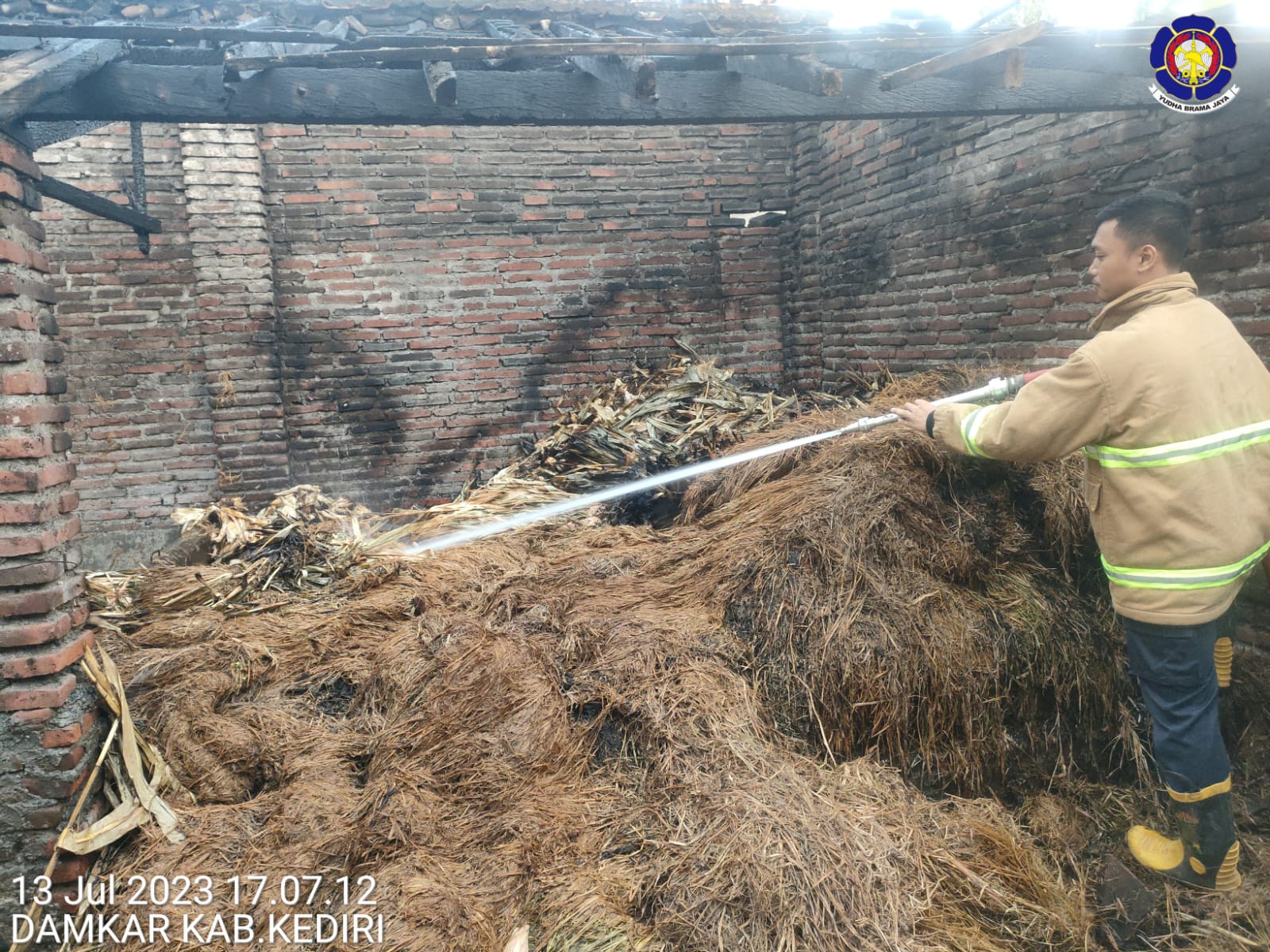 SEMPROT: Petugas PMK memadamkan api yang bakar jerami kandang.