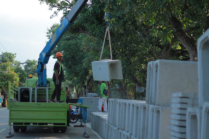 KEBUT PROYEK: Pekerja sedang mengangkut box culvert untuk akses jalan menuju bandara di Kecamatan Banyakan.