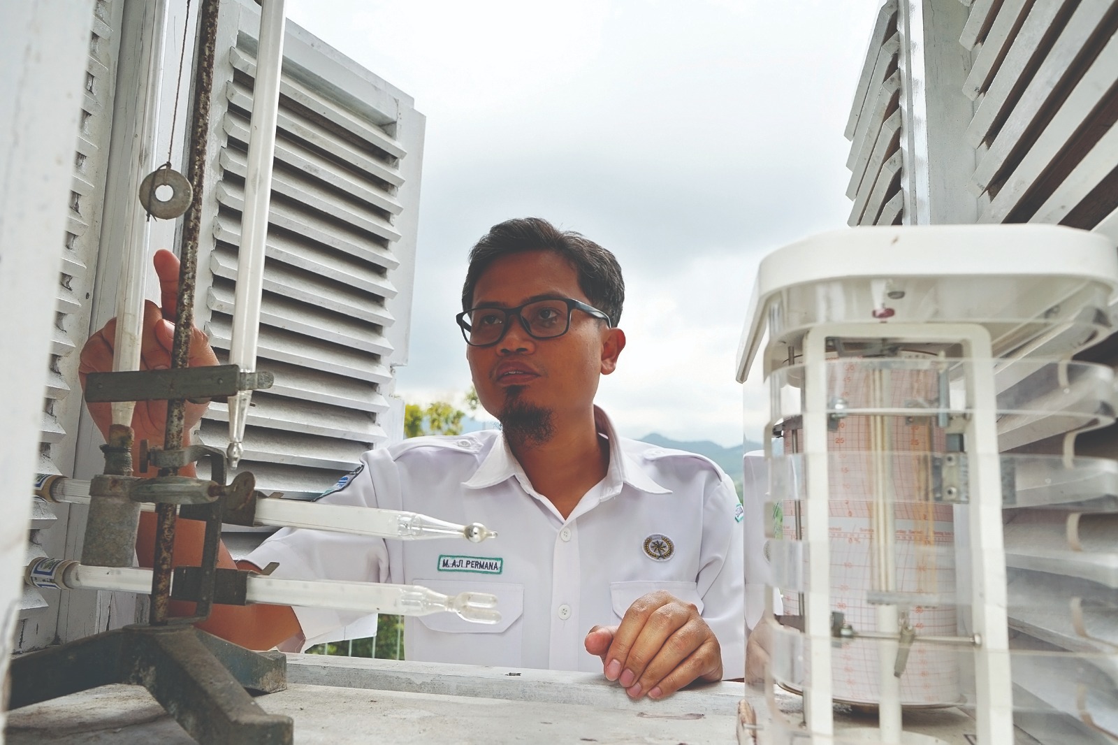PANTAU CUACA: M. Aji Permana, petugas BMKG Kabupaten Nganjuk mengamati alat pengukur suhu udara.