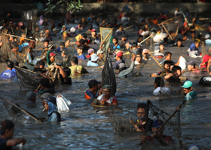 ANTUSIAS: Ribuan warga Desa Tanjung, Pagu mencebur ke Sumber Gundi untuk menjaring ikan dalam Grobyak Ikan kemarin pagi.