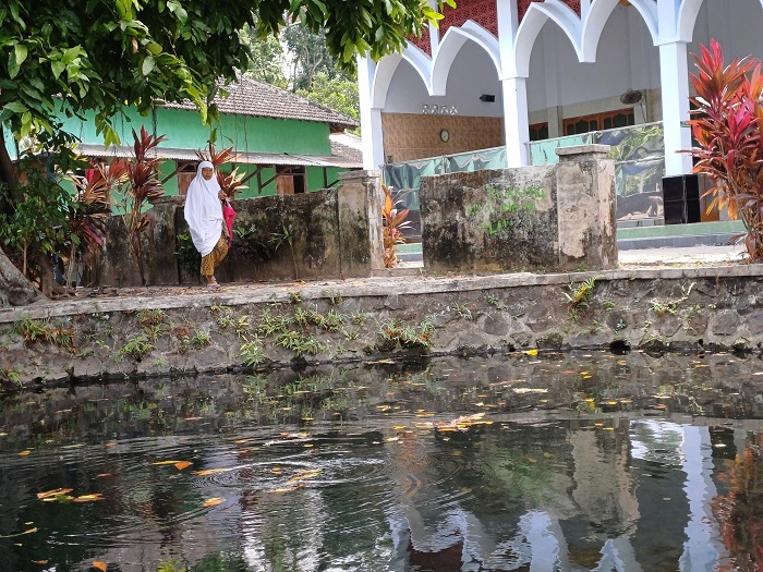 BERALIH FUNGSI: Warga setempat berjalan menuju masjid. Dulu, Sendang Gayam dipakai jemaah masjid untuk berwudu.