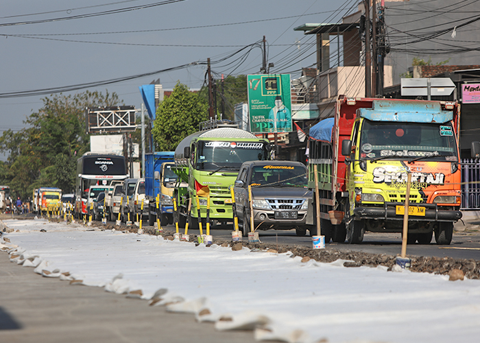 INFRASTRUKTUR: Kondisi lalu lintas di jalan raya Kediri-Nganjuk depan Pasar Gringging, Kecamatan Grogol kemarin. Pelaksana proyek mulai melakukan pengecoran jalan.