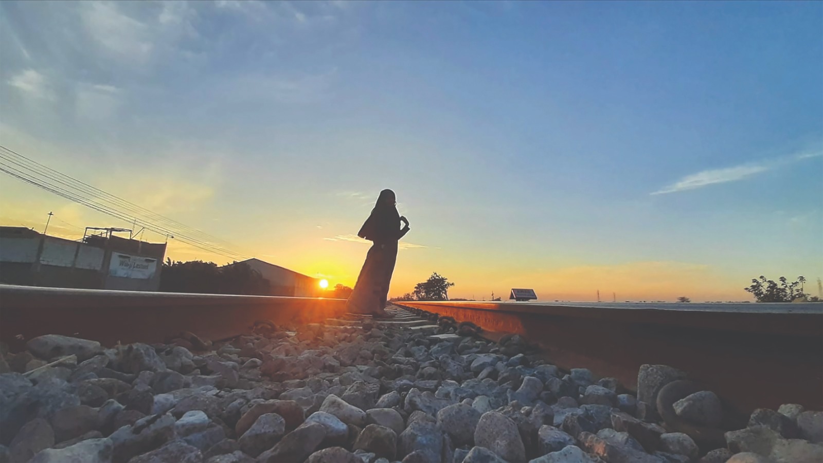 BERBAHAYA: Amalia foto di rel kereta api, Kecamatan Sukomoro saat sunrise kemarin. PT KAI melarang orang beraktivitas di rel KA.