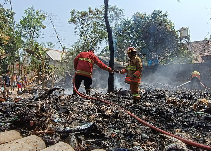 JADI ARANG: Petugas Damkar Kabupaten Kediri memadamkan api yang melahap tumpukan sampah di pekarangan milik Agus Nur Kholik, 50, di Desa Cerme, Kecamatan Grogol.