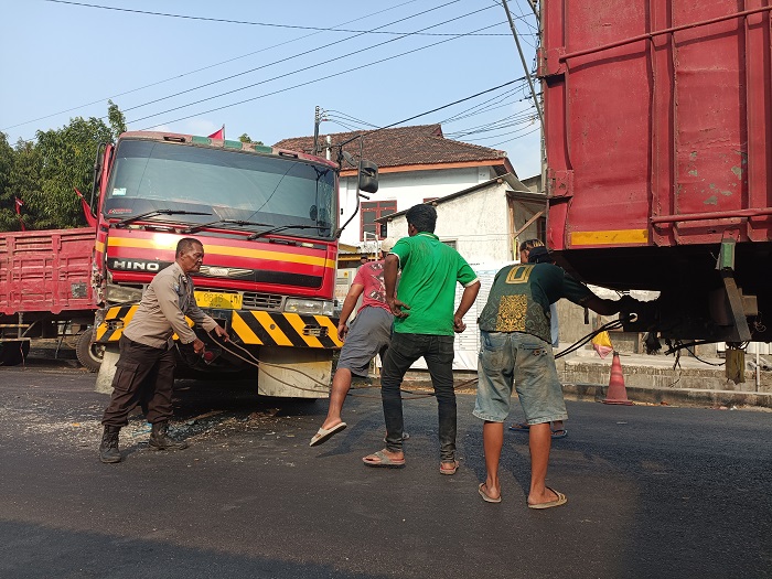 BAHU MEMBAHU: Petugas bersama warga berusaha mengamankan truk gandeng yang mengalami kecelakaan di jalan Totok Kerot Desa/Kecamatan Pagu kemarin sore.