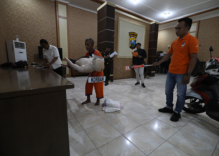 SADIS: Suprapto, 53, alias Totok memeragakan adegan saat mengangkat tubuh Ela yang pingsan dan hendak diperkosa, dalam rekonstruksi di Polres Kediri kemarin.
