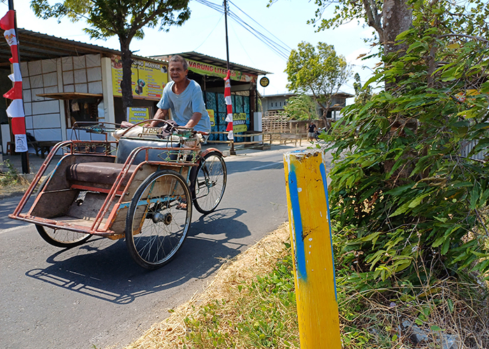 KAYUH BECAK: Seorang tukang becak melintasi jalur yang terdampak tol Kediri-Tulungagung di Kelurahan Gayam, Kota Kediri kemarin.
