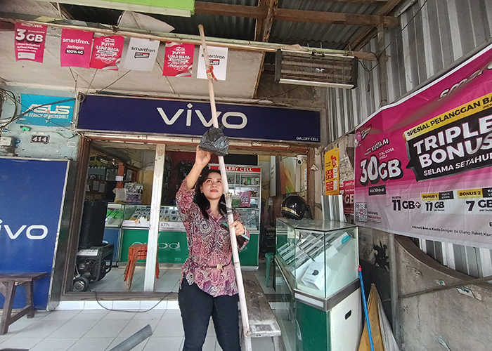 BUKTI TAWURAN: Devi, karyawan konter ponsel di area Pasar Kweden, Ngasem menunjukkan tongkat bambu yang sempat dipakai tawuran oleh pelaku.