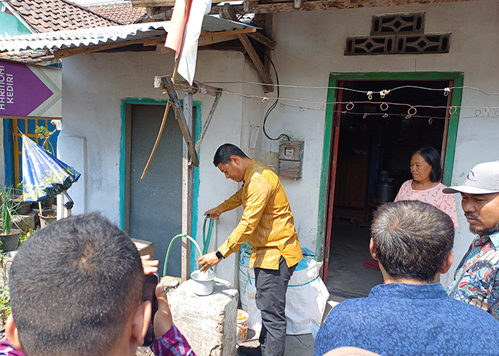 BERBAU TAJAM: Wali Kota Abdullah Abu Bakar mengecek air di salah satu rumah warga yang terdampak. Dia memastikan air tercemar bau minyak yang tajam dan licin. Foto bawah, tim dinas lingkungan hidup ke