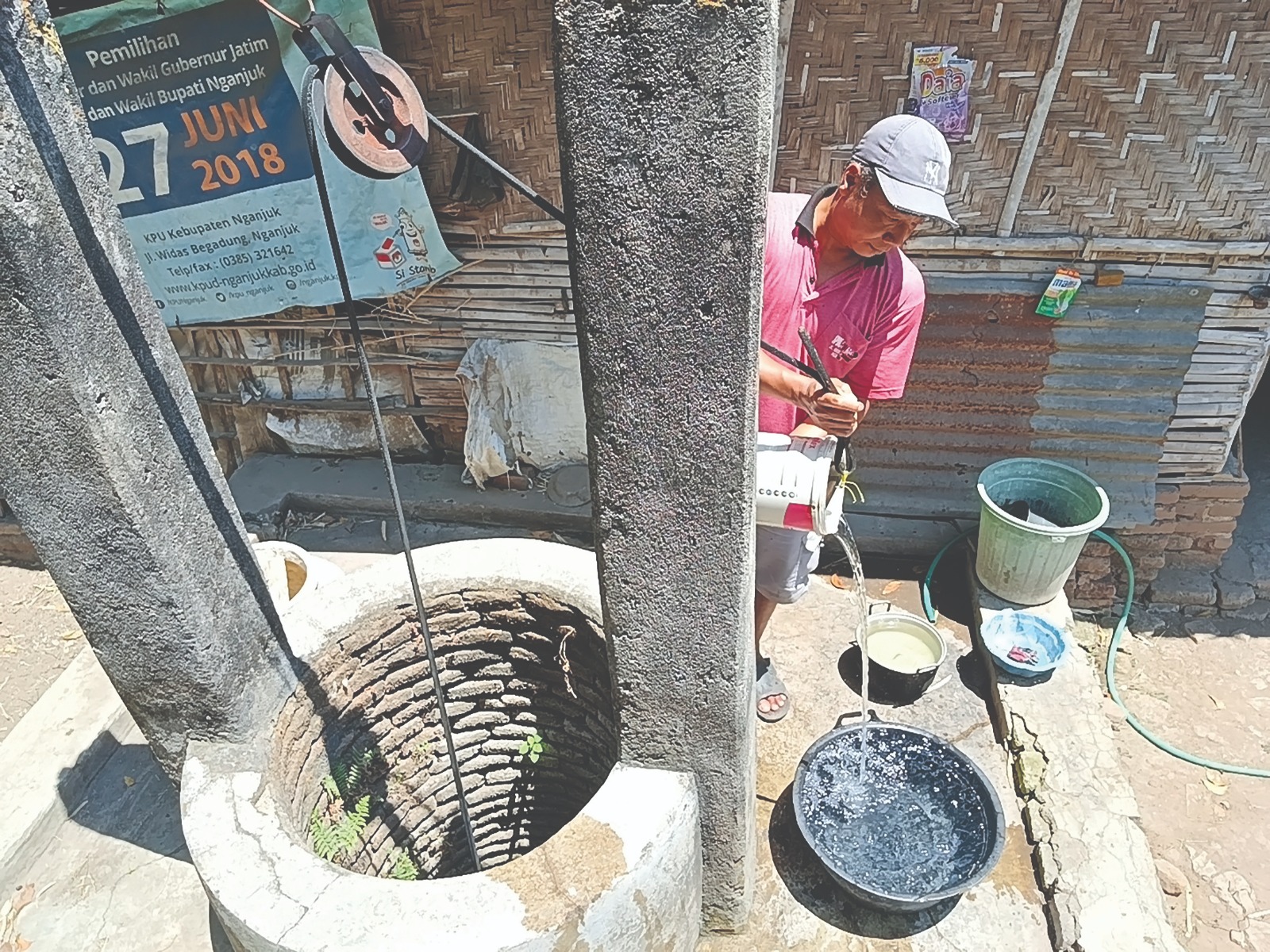 TRADISIONAL: Dardiri, warga Pace menimba air sumur untuk memenuhi kebutuhan sehari-hari. PDAM tak mengalir di 3 kecamatan.
