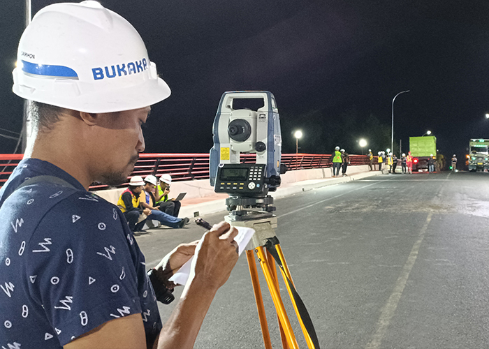 SERIUS: Petugas PT Bukaka Teknik Utama melakukan serangkaian pengujian beban di jembatan Alun-Alun Bandar, Kota Kediri pada Rabu malam (20/9).