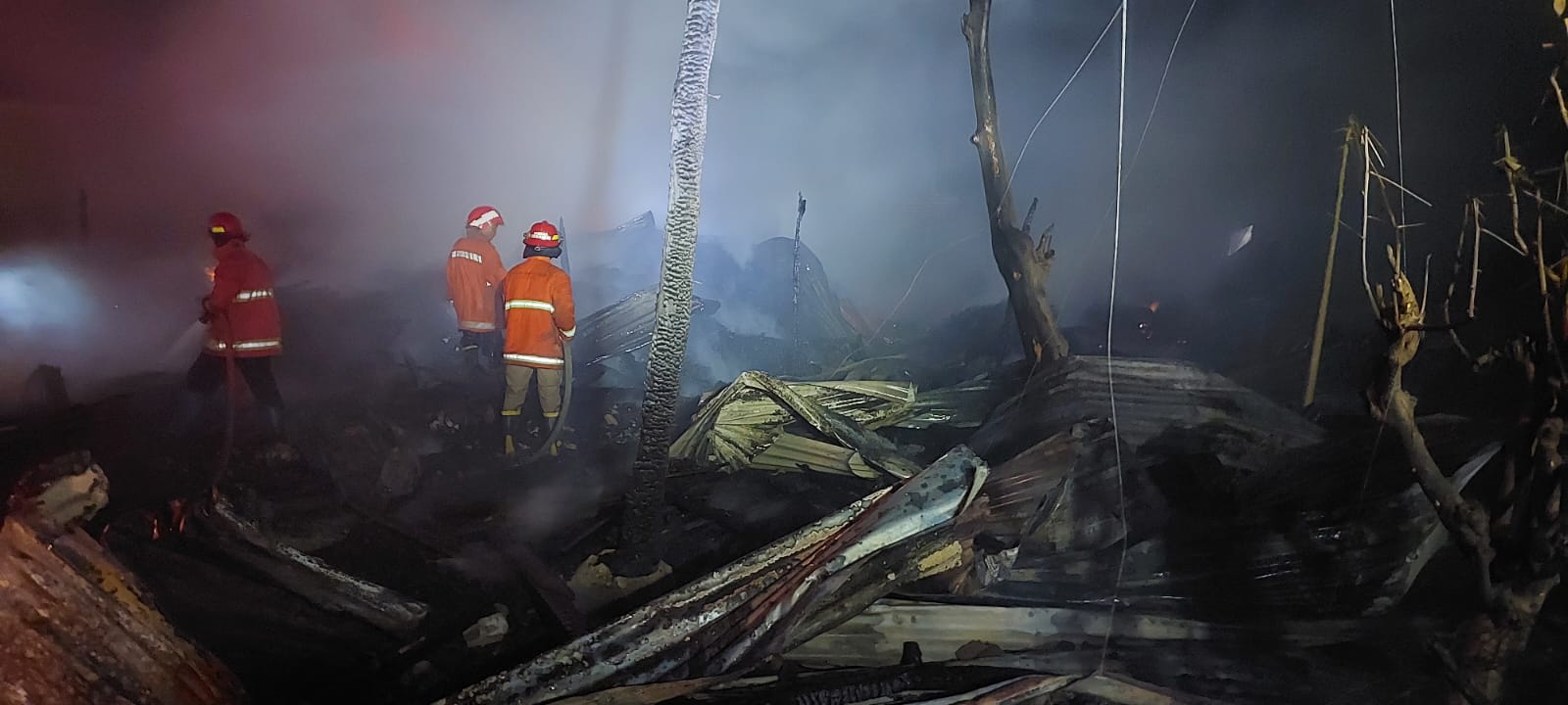 HANGUS: Petugas gabungan PMK Kota dan Kabupaten Kediri memadamkan gudang kayu yang terbakar pada Senin lalu.