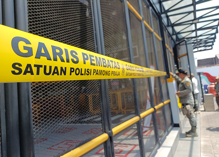 HARUS TUTUP: Tim Satpol PP Kota Kediri memasang segel di gerai Mie Gacoan  Jl Urip Sumoharjo. Aparat penegak perda itu meminta manajemen melengkapi izinnya lebih dulu.