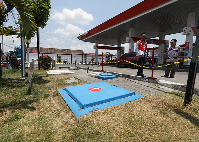 PEMICU CEMARAN: Tim Pertamina mengecek tangki 3 berisi Pertamax. Pipa yang tersambung dengan tangki inilah yang bocor dan mencemari sumur warga.