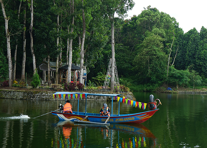 INDAH: Pengunjung menikmati keindahan sumber dengan menaiki wahana perahu. Di Sumber Jembangan banyak jenis pohon yang tumbuh dengan subur.