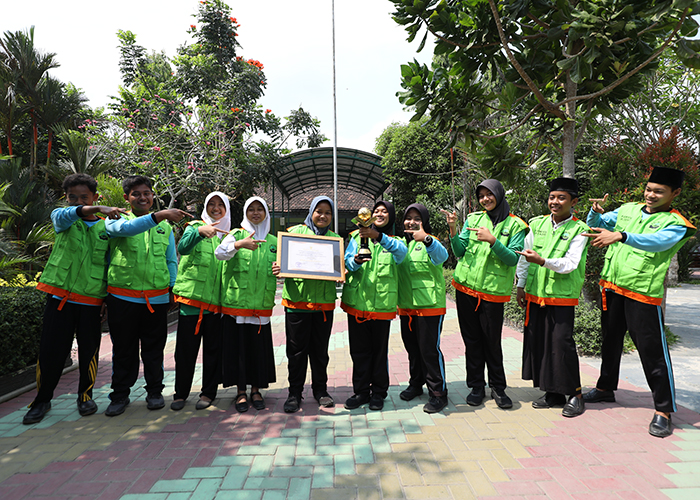 BUAH KERJA KERAS: Siswa MTsN 2 Kediri menunjukkan piagam dan trofi Adiwiyata Mandiri dari Dinas Lingkungan Hidup (DLH) Provinsi Jatim.
