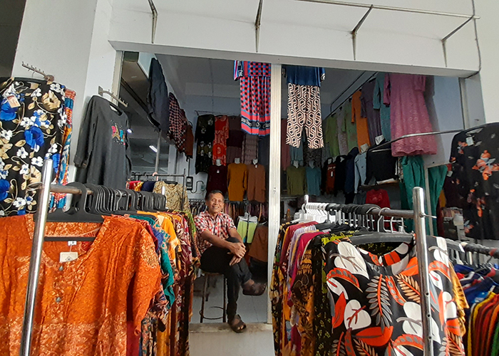 MENUNGGU: Agus Wantomi menunggu pembeli di sela-sela pakaian di kiosnya yang berada di Pasar Setonobetek.