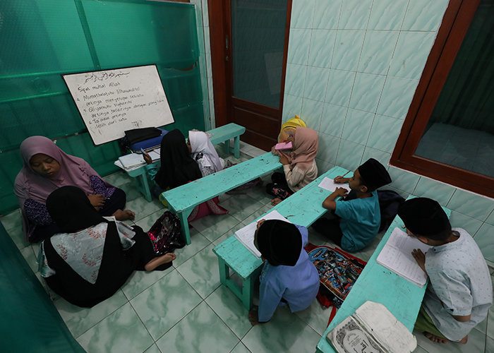 SUSUT: Hanik Solikatin, 45, guru madrasah diniyah di Kelurahan Tempurejo, Pesantren mengajar anak didiknya. Pemberlakuan sekolah lima hari membuat puluhan siswanya peretel.