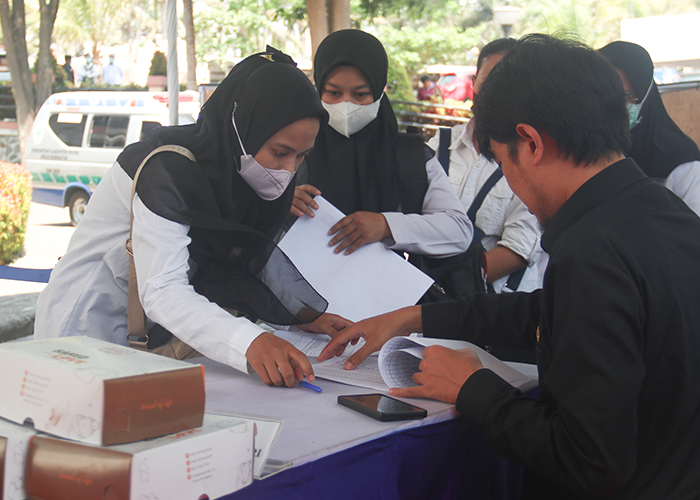 REGISTRASI: Sejumlah peserta CAT PPPK Kabupaten Kediri menandatangani presensi sebelum mengikuti body checking dan mengerjakan soal di Convention Hall SLG kemarin.