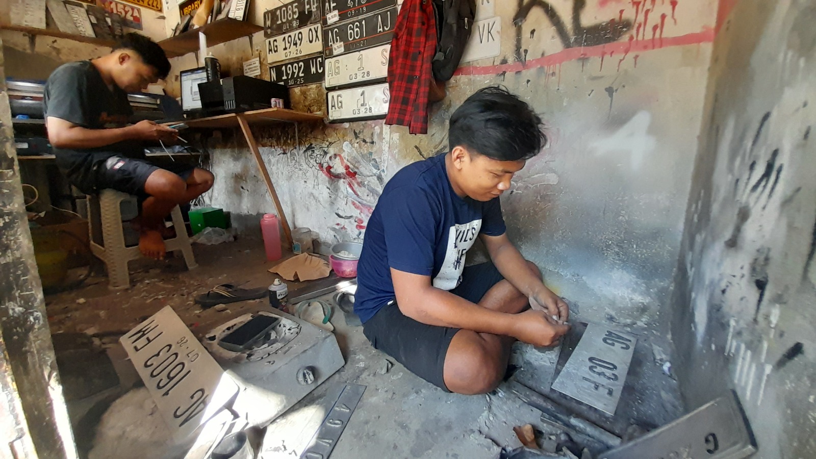 FOKUS: Agus sedang memasang atribut plat nomor di tempatnya. Meski dilarang, modifokasi plat nomor tetap diminati.