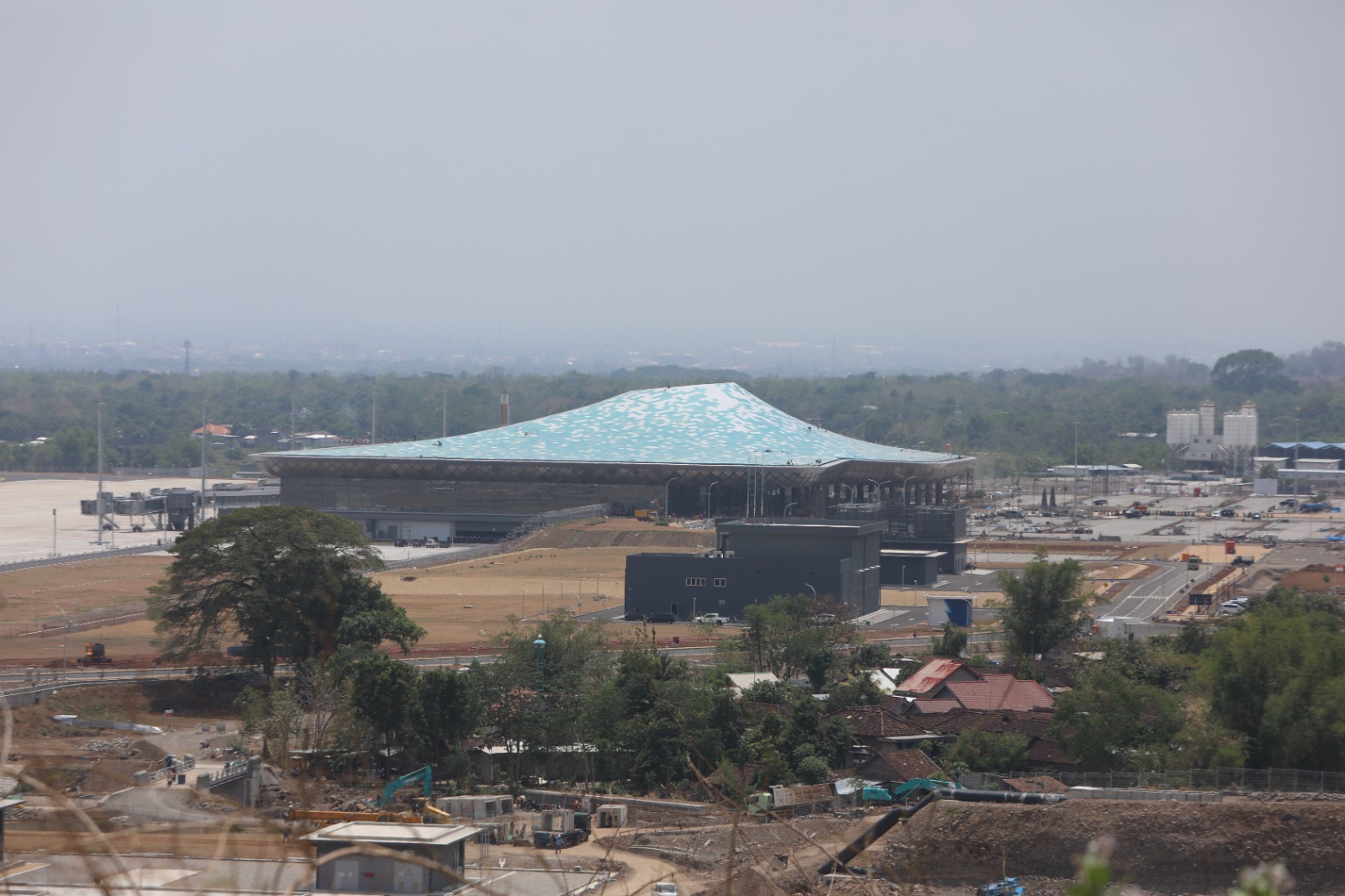 JADI PANTAUAN: Sejumlah pekerja melakukan finishing bangunan terminal penumpang Bandara Kediri yang di-desain berlubang di bagian tengah atas. Hari ini belasan kepala daerah akan diajak berdiskusi mem