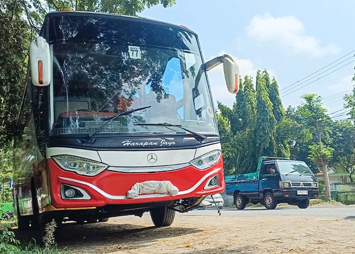 BARANG BUKTI: Bus Harapan Jaya yang terlibat kecelakaan maut di jalan raya Kediri-Tulungagung dengan sepeda motor yang dikendarai Mujito dan anak-istrinya. Akibat ini, istri Mujito meninggal.