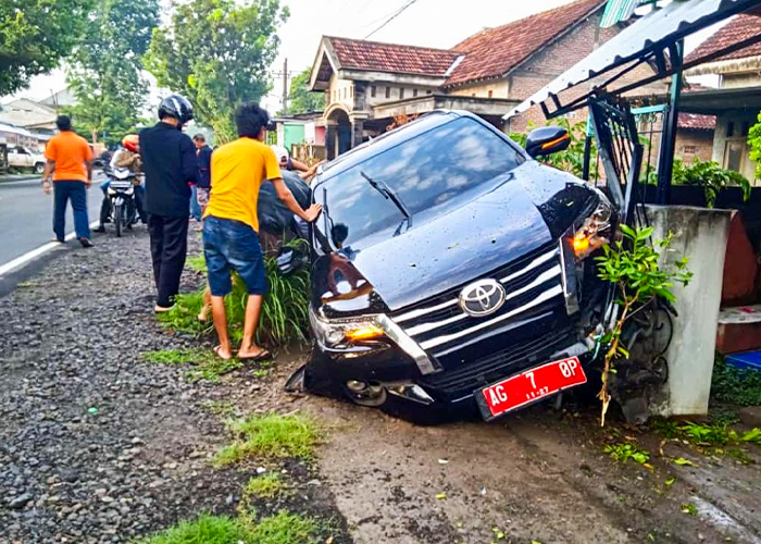 RINGSEK: Pagar rumah warga Desa Janti rusak akibat ditabrak mobil plat merah milik anggota DPRD Kabupaten Blitar. Kecelakaan terjadi diduga akibat menghindari sepeda motor yang menyebrang.