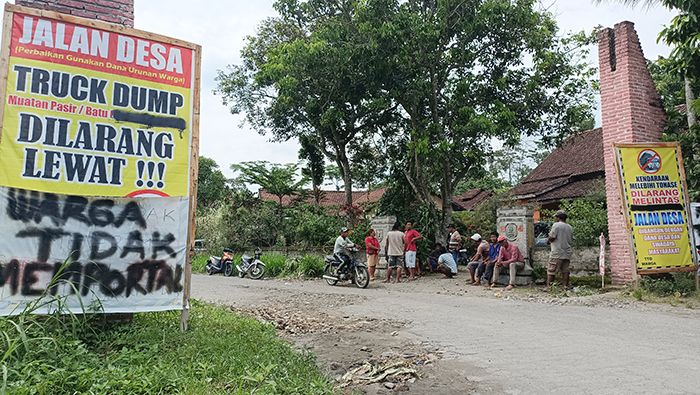 GERAM: Warga memasang banner larangan lewat bagi truk bermuatan di jalan Desa Margourip, Ngancar. Kemarin pagi warga memaksa puluhan unit truk pengangkut pasir untuk putar balik.