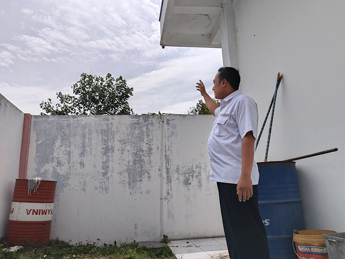 HINDARI CCTV: Koordinator SPBU Ngancar Sigit Setia Atmaja menunjukkan pagar yang diduga jadi jalur masuk perampok pada Rabu (7/2) dini hari lalu.