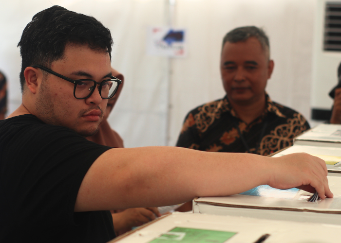 SERBAHITAM: Bupati Hanindhito Himawan Pramana memasukkan surat suara usai mencoblos di TPS Desa Sukorejo, Ngasem.