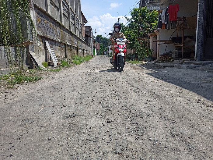 RUSAK: Sekretaris Desa Sumbercangkring Samsul Alawi menunjukkan jalan yang kondisinya rusak dan akan diperbaiki tahun ini.