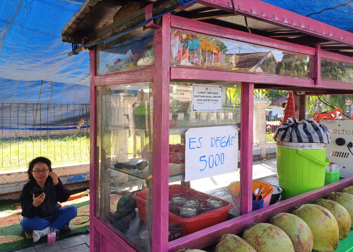 BANMOD: Seorang pengunjung menikmati minuman yang dijual oleh salah satu PKL penerima bantuan modal di Kota Kediri. Anggaran banmod tahun ini mengalami penurunan.