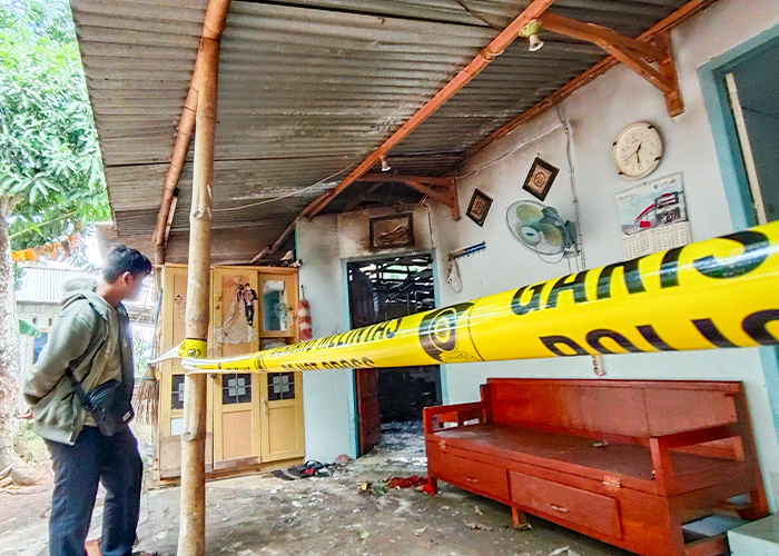 TERLARANG: Warga menyaksikan kondisi rumah Hadi Harsono, 61, di Desa Titik, Semen yang terbakar Senin (11/3) malam dari luar police line.