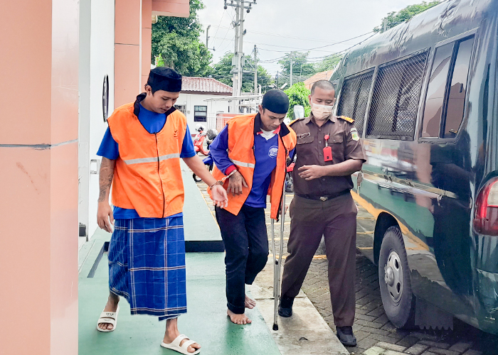 PESAKITAN: Dede Rahardi (tengah) harus berjalan dengan tertatih saat menuju kendaraan tahanan Kejari Kota Kediri. Terdakwa kasus pencabulan ini baru saja menjalani sidang di PN Kota Kediri.