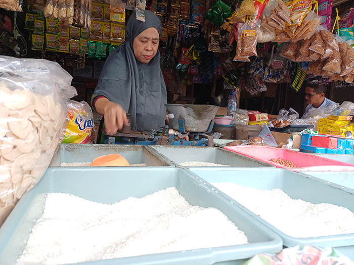 BAHAN POKOK: Salah seorang pedagang bahan pokok di Pasar Setonobetek Kota Kediri sedang melayani pembeli. Harga beras di pasaran mulai mengalami penurunan.