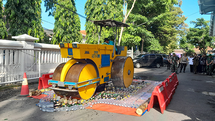 LINDAS: Ribuan barang bukti minuman keras hasil operasi pekat dimusnahkan oleh jajaran forkopimda di halaman Pemkot Kediri kemarin siang. Forkopimda juga memusnahkan narkoba dengan cara dibakar.