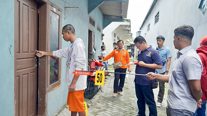 REKONSTRUKSI: Tersangka memperagakan adegan pembunuhan di sebuah rumah kos Pesantren.