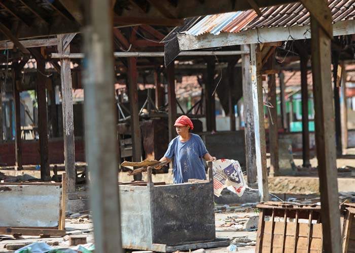 MENGAIS SISA: Pedagang Pasar Ngadiluwih memunguti beberapa barang di lapak lama yang masih bisa dimanfaatkan.