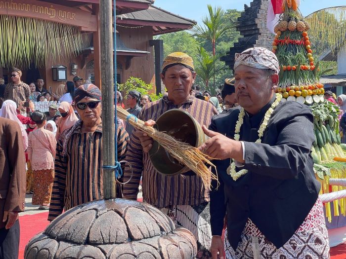 RITUAL : Kades Brumbung Tohari mencipratkan air  ke benda purbakala yang dimiliki pemdes, ketika  berlangsung bersih desa pada 2023 lalu.