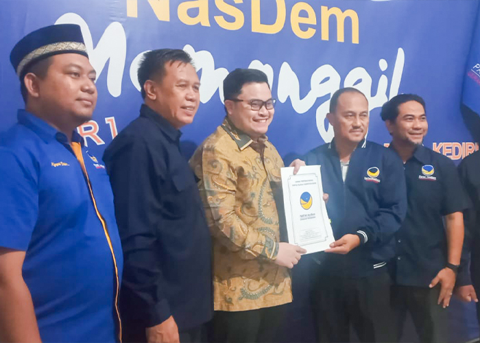 RESMI MENDAFTAR: Bupati Hanindhito Himawan Pramana (baju batik) menunjukkan formulir partai Nasdem bersama Ketua DPD Nasdem Lutfi Mahmudiono.