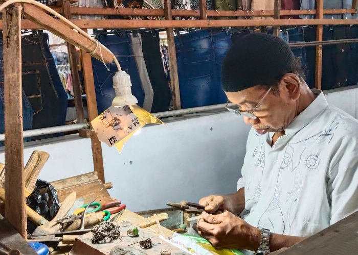 BERTAHAN: Abdul Muhaimin mengerjakan pesanan konsumen berupa perhiasan perak, di kiosnya.