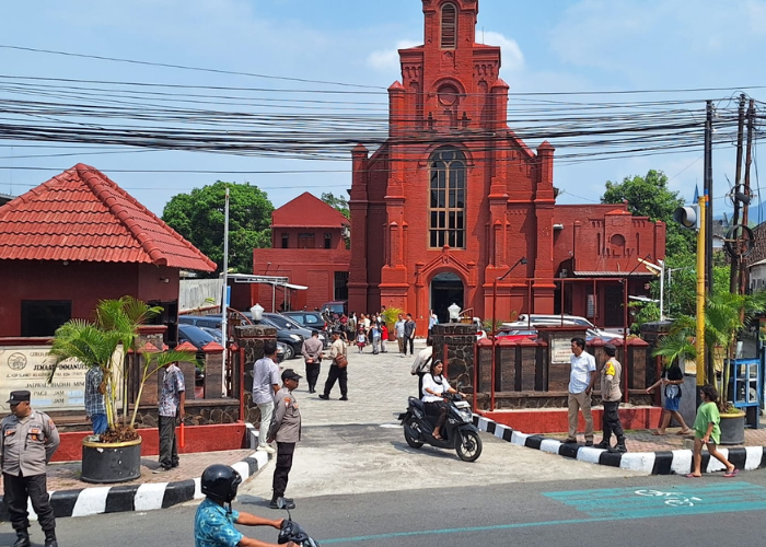 KENAIKAN ISA AL MASIH: Polisi menjaga ketat gereja merah di Mojoroto. Selain periksa jemaat petugas juga mengatur arus lalu lintas.
