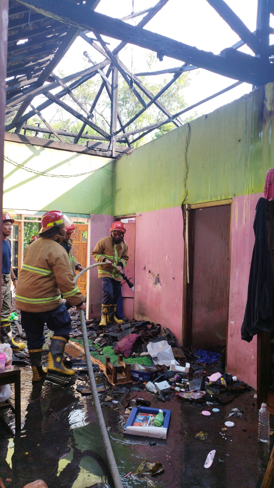 Petugas pemadam kebakaran mencoba menjinakkan api yang membakara rumah di Puhsarang, Kabupaten Kediri, Rabu (15/5).